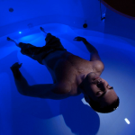 Man relaxing in floatation tank